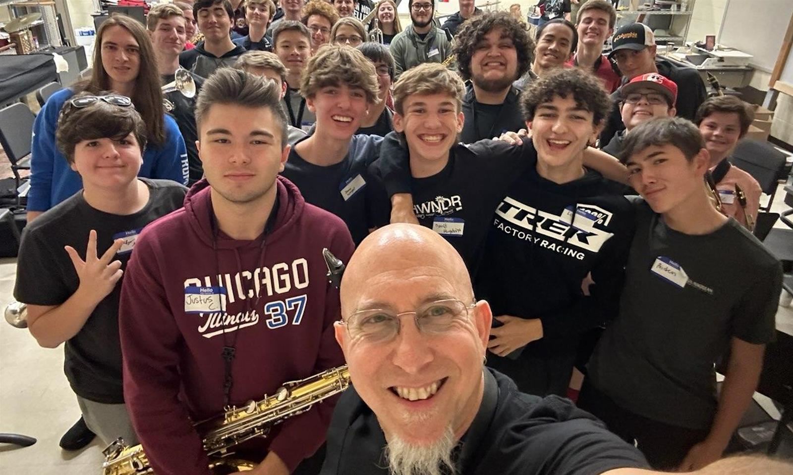 An instructor and students smile